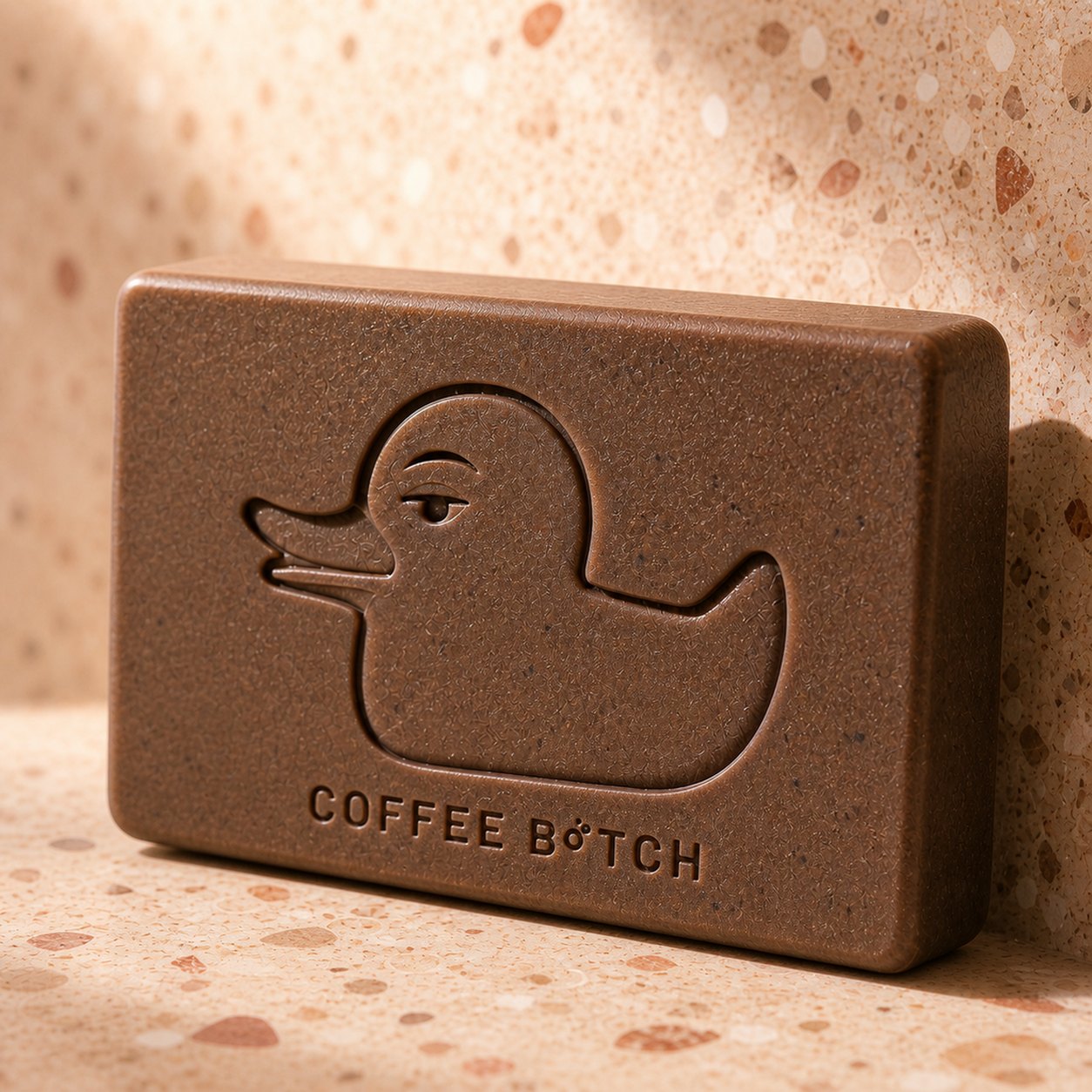 Gros plan du savon Coffee B*tch, brun café, canard gravé dans la masse